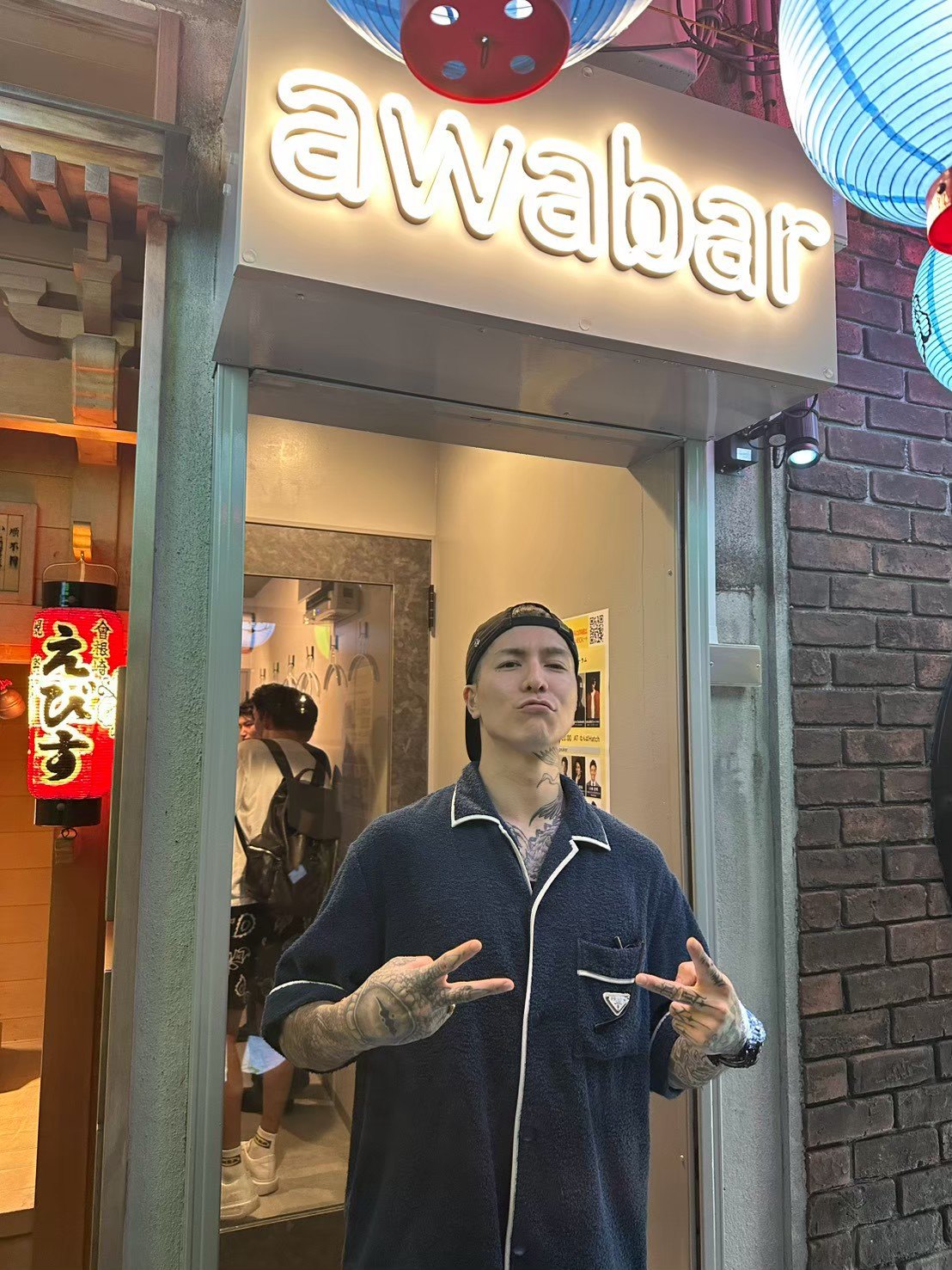 awabar Osakaの看板の前でポーズをとるDJふぉいさん