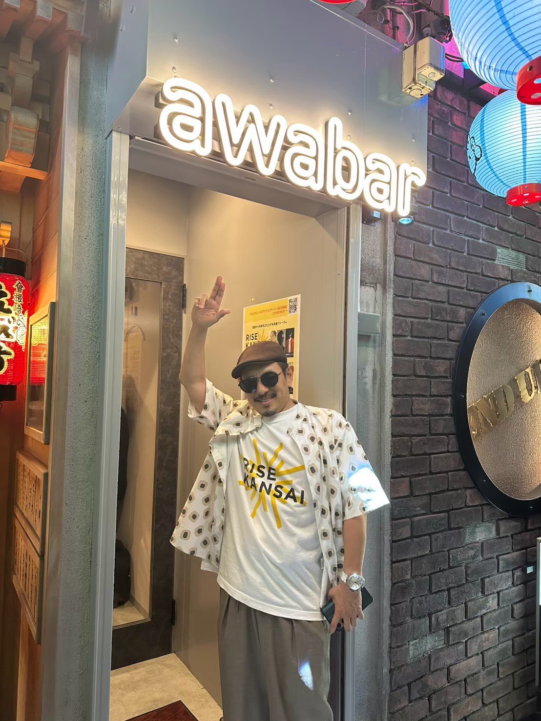 awabar Osakaの入口で手を上げる三木道三（DOZAN11）さん