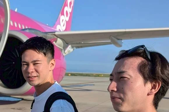 那覇空港でPeachの機体の前を歩く社員たち