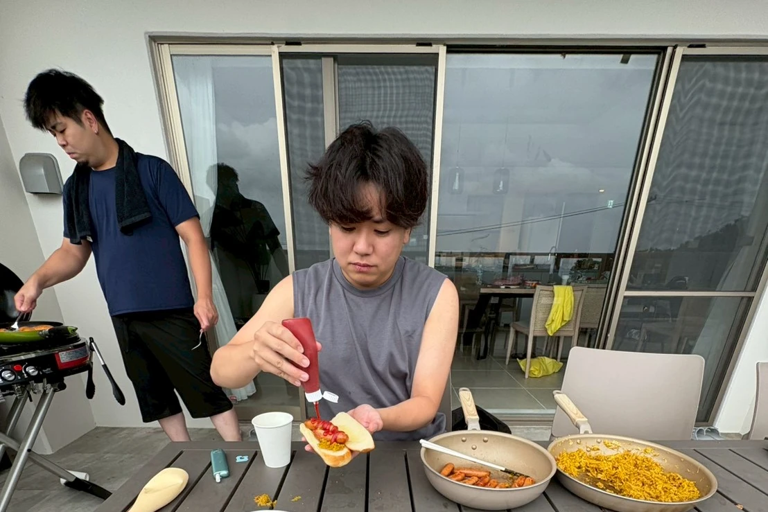 ヴィラのテラスでBBQの準備をする社員