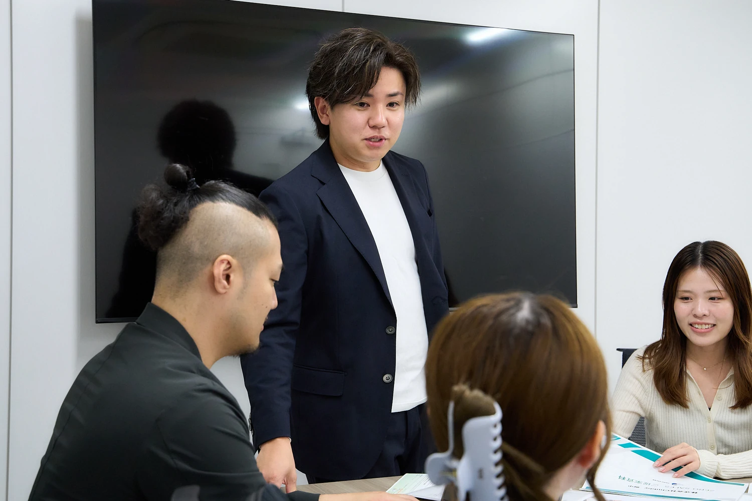 会議でメンバーに話す社員