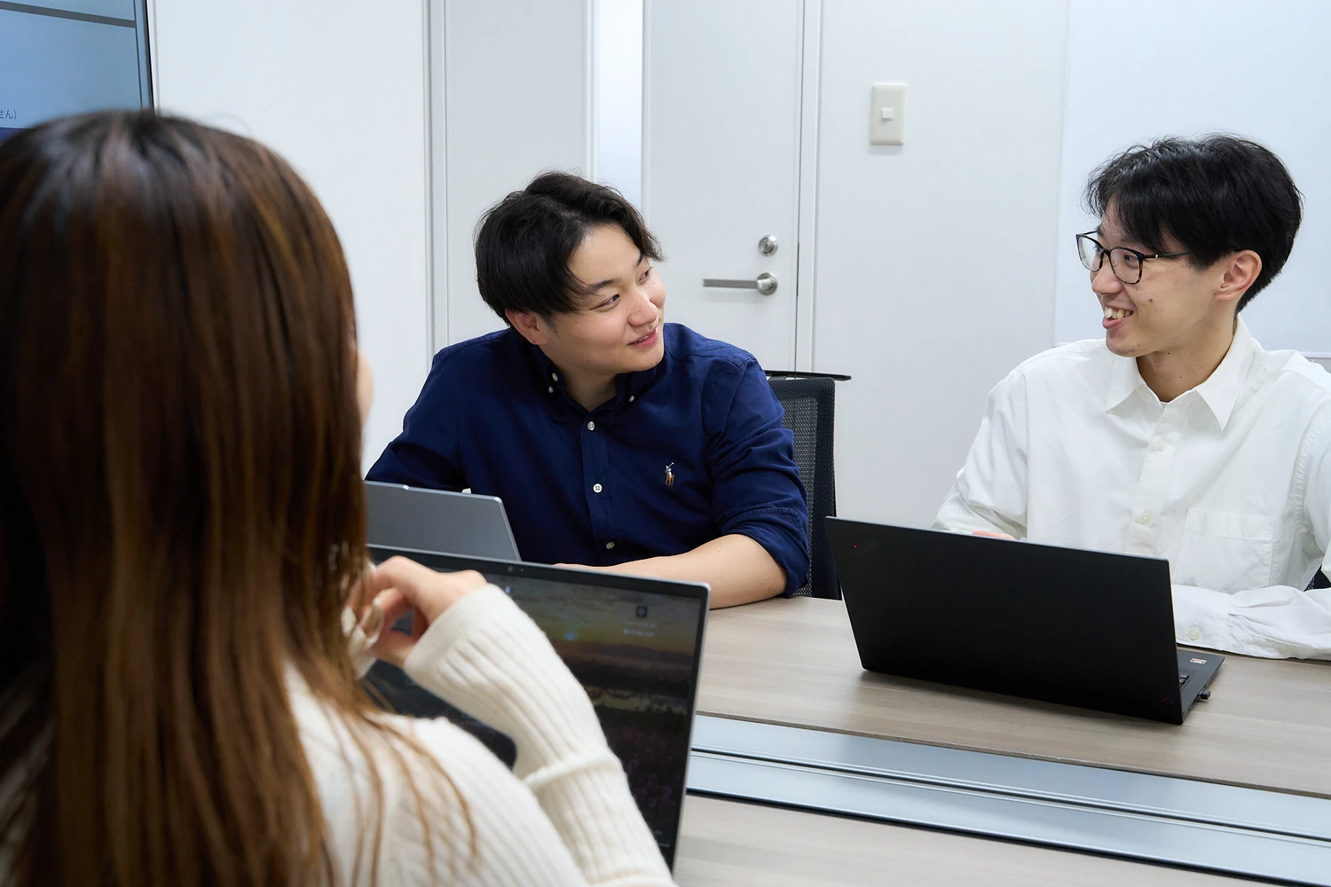 テーブルで打ち合わせをする社員