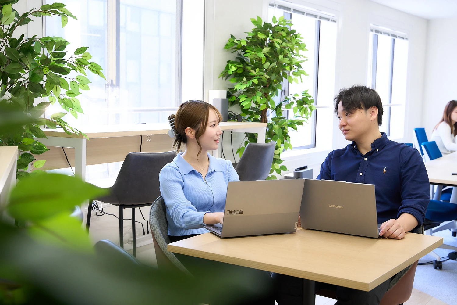 テーブルで向かい合って話す社員