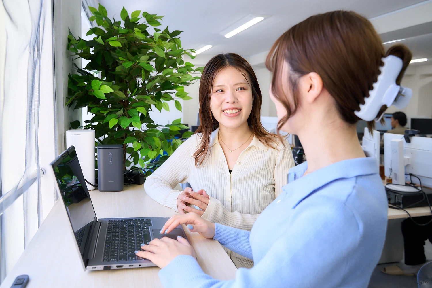 笑顔で話しながら作業する社員